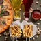 Delicious Italian food on table. Pizza, French fries, oil or wine bottles, ketchup and pistachios on it. Flat lay or top
