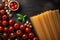 Delicious Italian spread, pasta, tomatoes on rustic backdrop top view