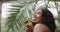 Delicious juicy kiwi in the hands of a girl smiling at the camera. Portrait of a mixed race African American girl posing