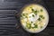 Delicious latino american chicken broth with potatoes, eggs, white cheese and cilantro close-up in a bowl. horizontal top view