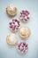 Delicious lemon and raspberry tartlets with meringue on a white vintage plate. Sweet treat on a light blue background. Flat lay an