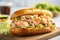 Delicious lobster roll with avocado tossed with mayo with lettuce in a toasted brioche bun on wooden board