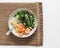 Delicious lunch - risoni pasta, shrimp and arugula, cucumber, celery salad on a light background, top view