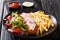 Delicious lunch of roasted pollock breaded with french fries and fresh salad close-up on a plate and sauces. horizontal