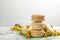 Delicious macarons and flowers on white marble table