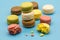 Delicious macarons full and bitten and crumbs arranged on colorful background