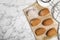 Delicious madeleine cakes and powdered sugar on white marble table, flat lay. Space for text