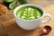 Delicious matcha latte in cup and spoon on wooden table, closeup