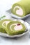 Delicious Matcha Swiss Roll Cake slices with strawberry cream on white background