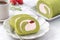 Delicious Matcha Swiss Roll Cake slices with strawberry cream on white background