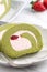 Delicious Matcha Swiss Roll Cake slices with strawberry cream on white background