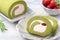 Delicious Matcha Swiss Roll Cake slices with strawberry cream on white background