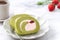 Delicious Matcha Swiss Roll Cake slices with strawberry cream on white background