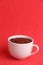 Delicious melted chocolate in the white cup on the red background