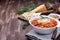 Delicious minestrone soup served with crispy bread, on wooden background, horizontal, copy space