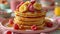 A delicious morning treat - stacks of pancakes served with banana, raspberry and a drizzle of syrup