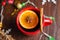 Delicious mulled wine alcoholic warm drink with cinnamon and star anise in a red cup. The concept of preparing for Christmas,