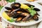 Delicious mussels in white wine with lemon, garlic, herbs and spices in a white plate