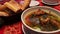 Delicious national Azerbaijani lamb soup in restaurant. Bouillon of meat in a white plate on a background of bread