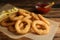 Delicious onion rings, fries and ketchup on table, closeup