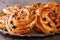 Delicious pain aux raisins spiral buns with raisins and custard close-up in a plate. horizontal