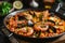 A delicious pan of paella filled with succulent shrimp and plump mussels cooked to perfection, Dish of traditional Spanish Paella