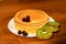 Delicious pancakes with honey, kiwi and berries.