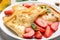 Delicious pancakes with strawberries, cottage cheese and honey on light table, closeup