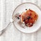 Delicious pancakes with syrup and berries on stylish plate on rustic table with vintage fork, flat lay. Yummy homemade breakfast.