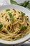 Delicious pasta with anchovies, olives and basil on plate, closeup