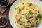 Delicious pasta with anchovies, olives and basil on wooden table, flat lay