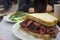 Delicious pastrami sandwich with side of pickles