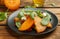 Delicious persimmon salad served on wooden table, closeup