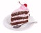 A delicious piece of chocolate cake with cherry cream and canned cherries on a white plate with a teaspoon, close-up