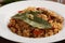 Delicious pilaf and bay leaves on plate, closeup