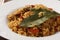 Delicious pilaf and bay leaves on plate, closeup