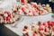 Delicious pink candy bar at wedding reception or christmas celebration. Pink and white macarons,cupcakes, desserts on stand,