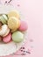 Delicious pink and green macaroons on pink paper, flat lay. Colorful macarons with confetti, candy bar for wedding on birthday.