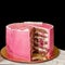 Delicious pink high layered cake for christening or birthday. Cut a piece of cake. Isolated on black background