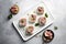 Delicious pink and white somen canapes with salted plum and prosciutto ham on a white platter, AI generated