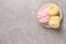 Delicious pink and yellow marshmallows on grey table, top view. Space for text