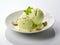 Delicious pistachio ice cream with nuts in a decorative plate on a white background