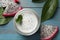 Delicious pitahaya smoothie, fruit and fresh mint on light blue wooden table, flat lay