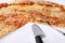 Delicious pizza Margherita with fork and knife. Take out freshly baked Italian traditional classic pizza being held in a box.