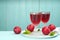 Delicious plum liquor, ripe fruits and mint on table against light blue background, space for text. Homemade strong alcoholic