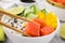Delicious poke bowl with salmon, lime and vegetables on table, closeup
