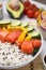 Delicious poke bowl with salmon, rice and vegetables on table, closeup