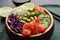 Delicious poke bowl with vegetables, fish and edamame beans on table, closeup