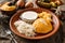 Delicious polenta with cheese, scrabble egg and sour cream on plate on rustic wooden background. Traditional Romanian food, close