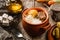Delicious polenta with meat, cheese and sour cream in bowl on rustic wooden background. Traditional Romanian food, close up